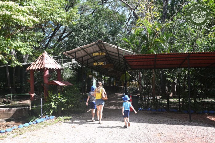 entrance of a building with people walking in and a sign that says welcome