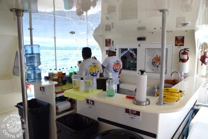 people standing behind a bar inside a boat