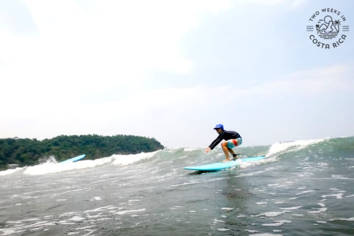 older kid catching a wave on a surfboard