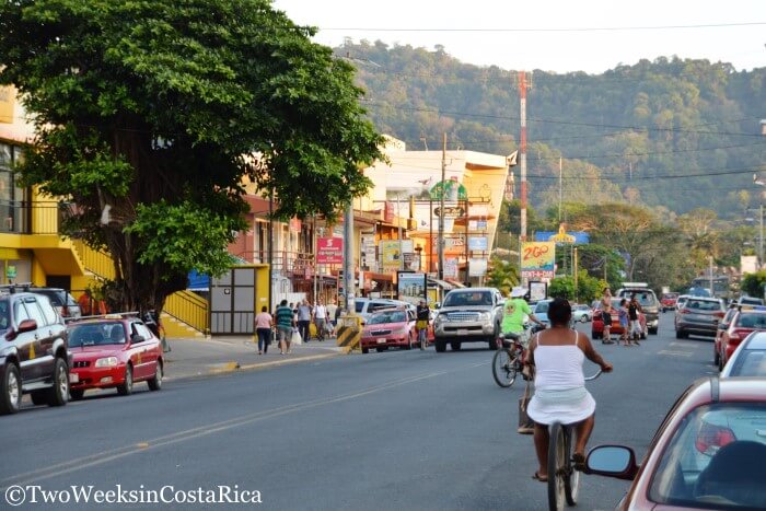 many people walking and riding bikes on the main street in jaco costa rica