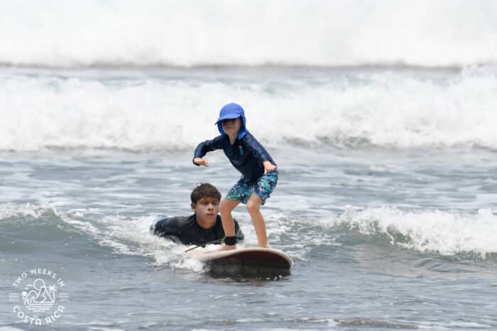 young kid taking a surf lesson in jaco
