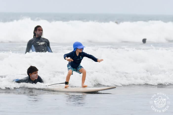 kid on a surf board in the ocean with an instructor