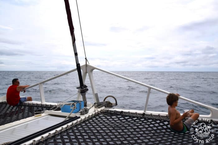 person sitting on a trampoline at the front of a boat