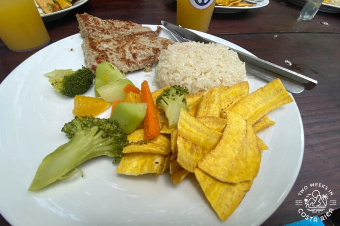 a plate of food with fish, rice and chips