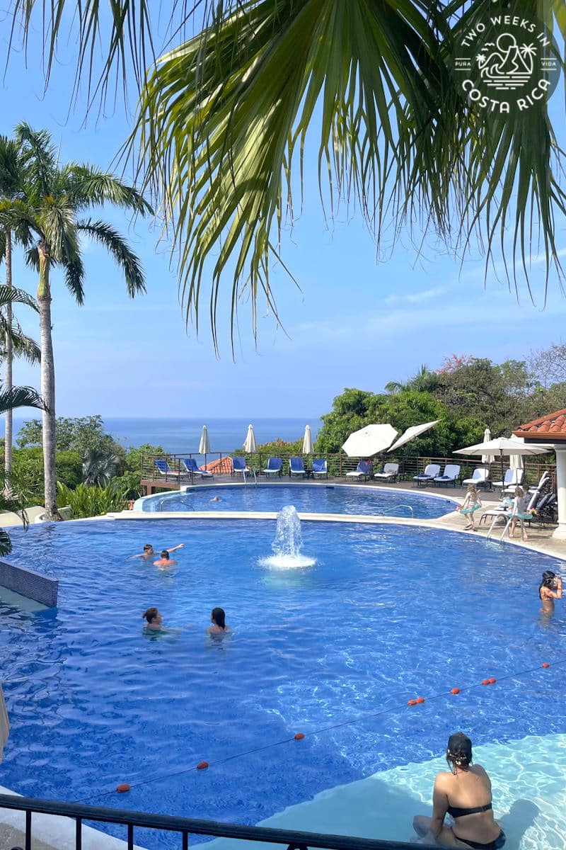 people swimming in a pool with a fountain in the middle
