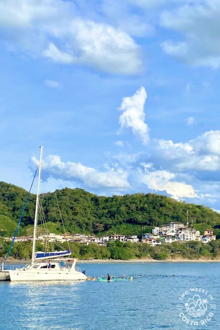 boat with a small town and green hillside in background