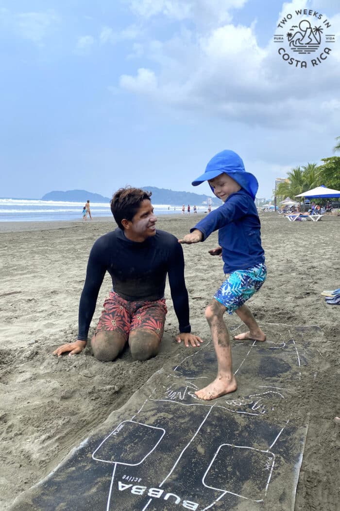 a kid learning proper form for surfing with an instructor