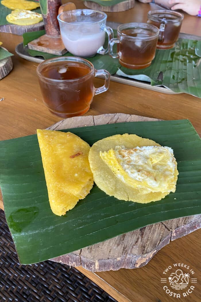 An empanada and tortilla served on a banana leaf